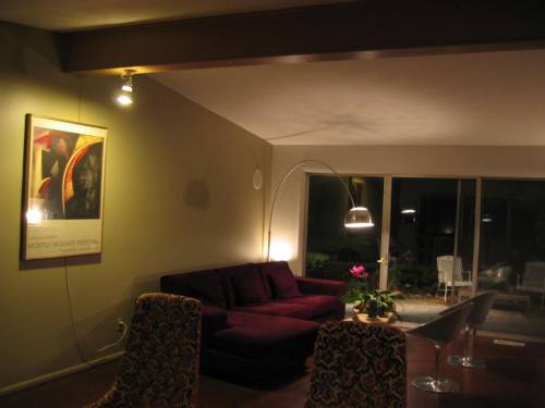 Upper living room (back half) at night with ceiling beam and triple slider to backyard patio
