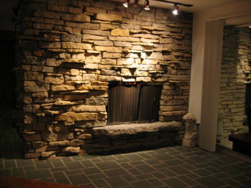 Living area downstairs at night; fireplace in stacked stone wall