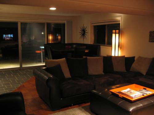 Living area downstairs at night; front of room looking toward triple slider that opens to front patio